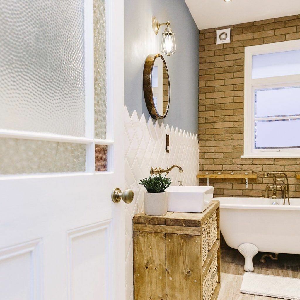 A traditional bathroom with industrial brass wall lighting. 