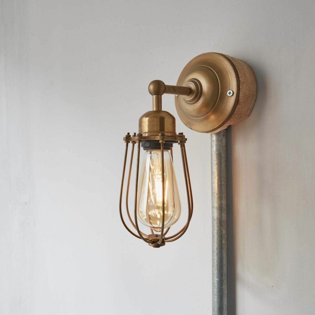 A brass cage wall light with an industrial bulb from Industville. 