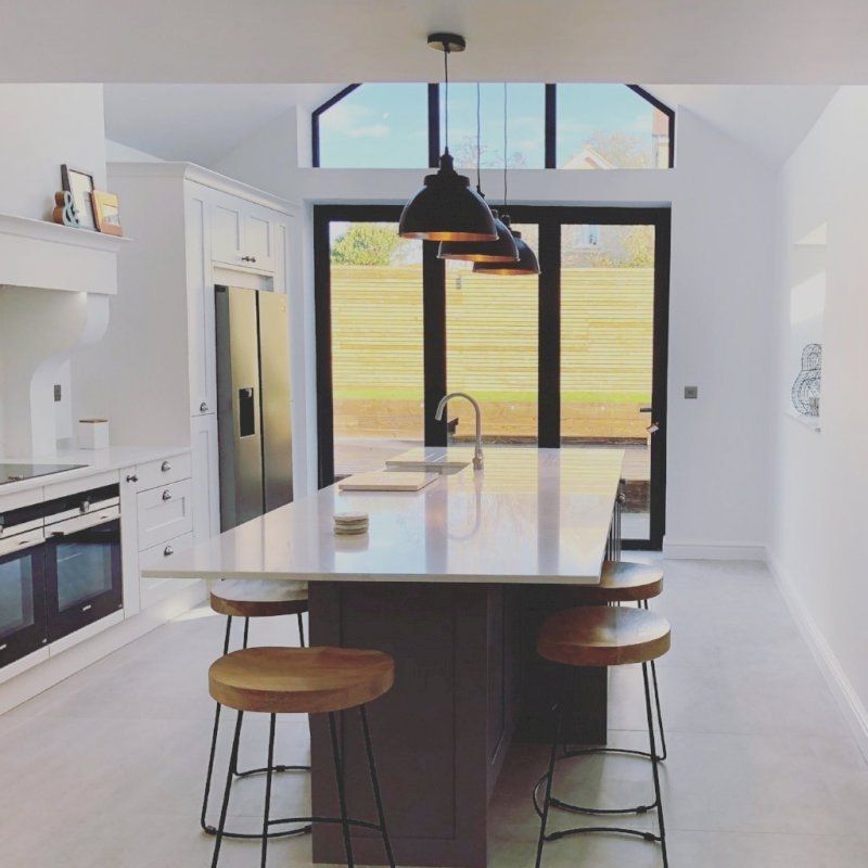 A white kitchen island with pewter and copper industrial lighting 
