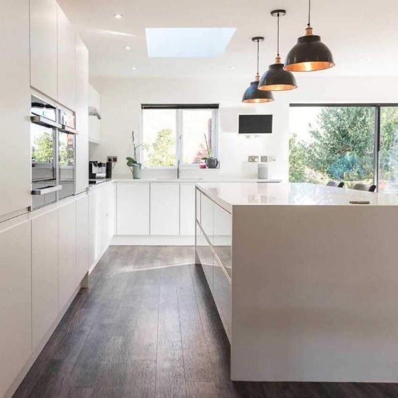 A sleek modern white kitchen with pewter and copper industrial lighting by Industville 