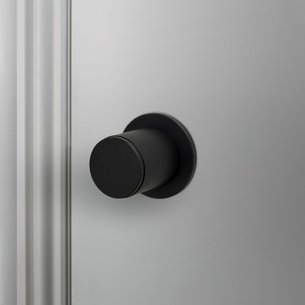 A Buster and Punch Welders Black Linear door knob on a grey door.